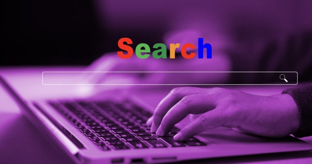 persona che scrive al pc con search in primo piano